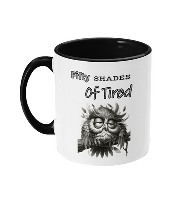  A white ceramic coffee mug with a black interior and handle, featuring a grayscale illustration of a tired-looking owl. The humorous text on the mug reads, “Fifty Shades of Tired,” making it a fun design for anyone who can relate to feeling exhausted.