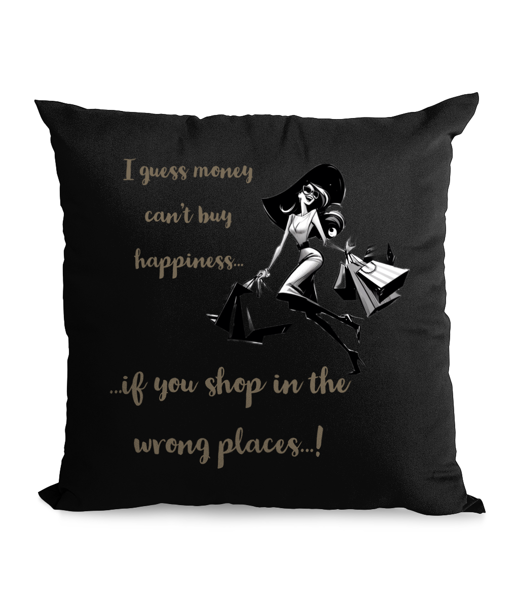 Black cushion with a fashionable woman carrying shopping bags and the text: ‘I guess money can’t buy happiness… if you shop in the wrong places!’”