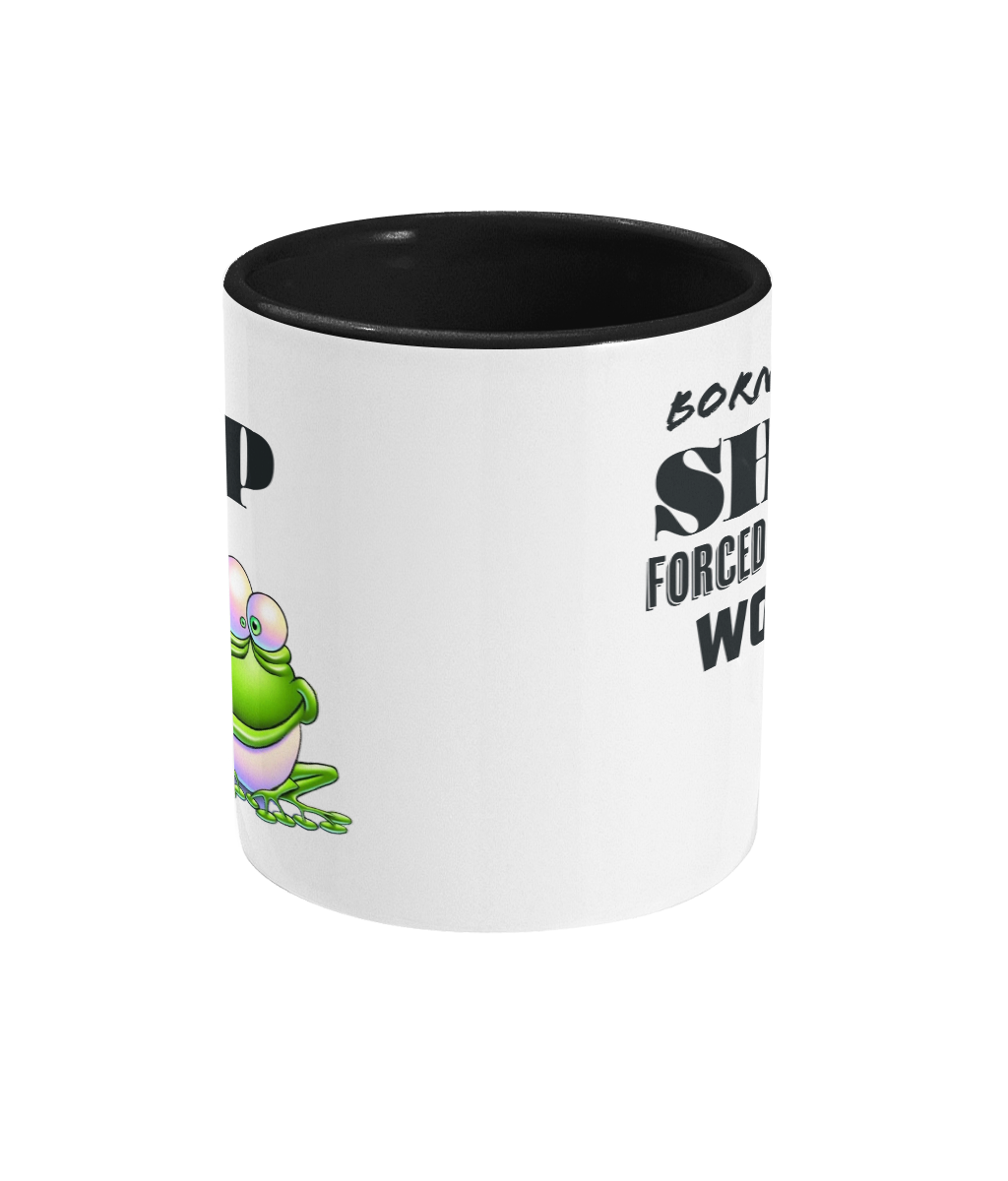 A white ceramic coffee mug with a black interior and handle, featuring the humorous text, “Born to shop, forced to work.” The design includes a colorful cartoon illustration of a happy green frog sitting on a lily pad, adding a playful and whimsical touch. The text is styled in bold fonts for emphasis.