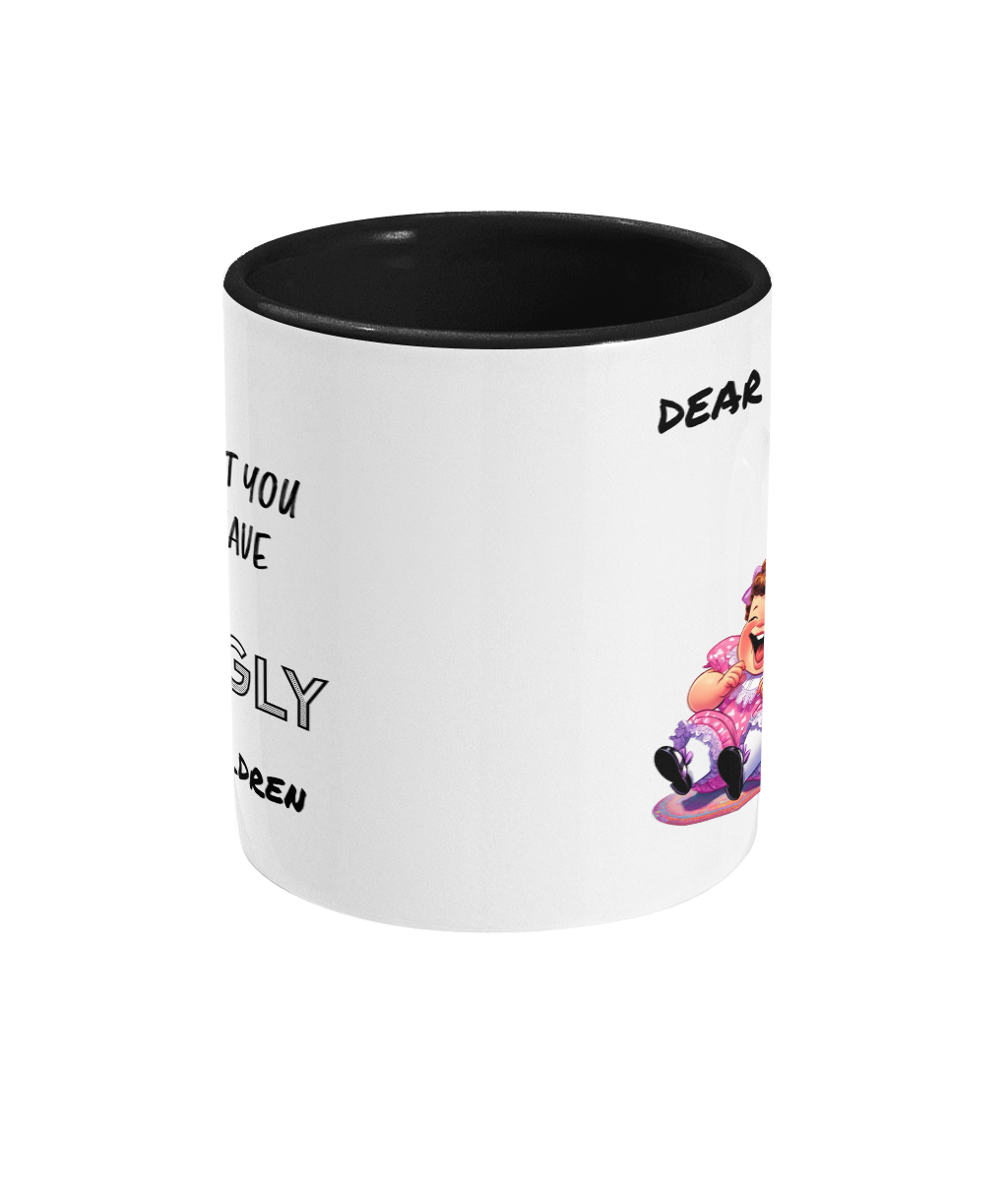 A white ceramic coffee mug with a black interior and handle, featuring the humorous text, “Dear Mum… At least you don’t have ugly children.” The design includes a colorful cartoon illustration of a laughing child in a pink dress, adding a cheeky and playful tone to the mug. The text is styled in a mix of casual and bold fonts.