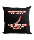 Black cushion with cheeky quote: ‘I’m Not Wearing Any Socks, and I Have the Panties to Match,’ featuring legs in red high heels.”