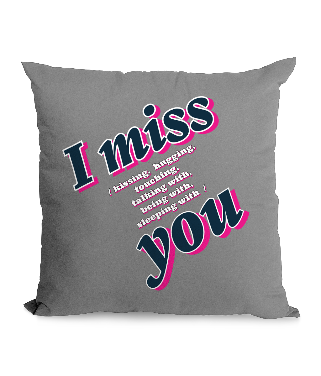 Black cushion with bold text: ‘I Miss You – Kissing, Hugging, Talking, Sleeping With You’ in pink and blue hues.”