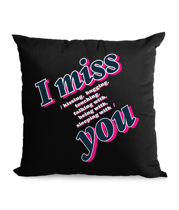 Black cushion with bold text: ‘I Miss You – Kissing, Hugging, Talking, Sleeping With You’ in pink and blue hues.”